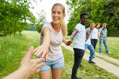 File de gens souriants qui se tiennent par la main