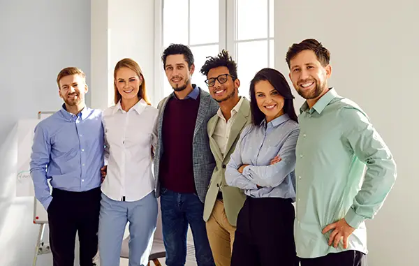 Photo d'une équipe de six personnes souriantes bras dessus bras dessous