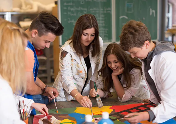 Quatre jeunes peignent une affiche